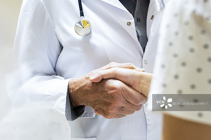 男医生在医疗机构内与女患者握手的特写镜头图片素材
