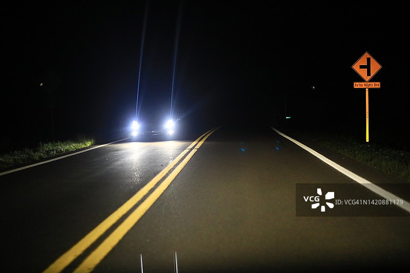 黑暗道路上的车头灯图片素材