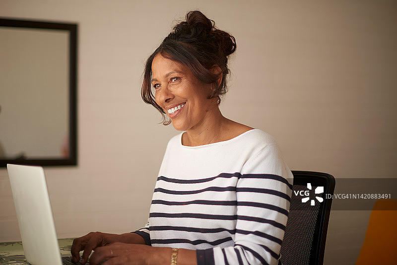 在家用电脑上网、搜索或打字的老年妇女图片素材