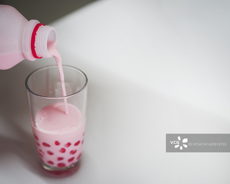 将草莓味牛奶倒入西米玻璃杯中图片素材