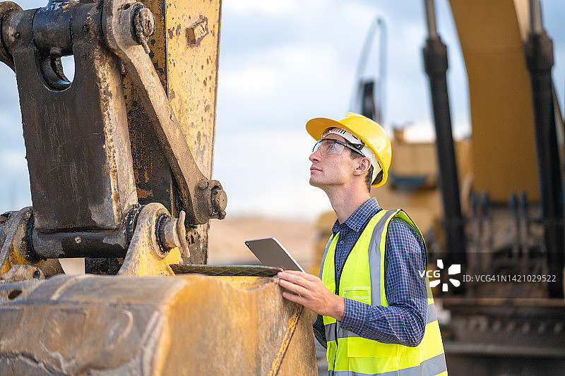 男性工程师在建筑工地维修土壤挖掘机图片素材