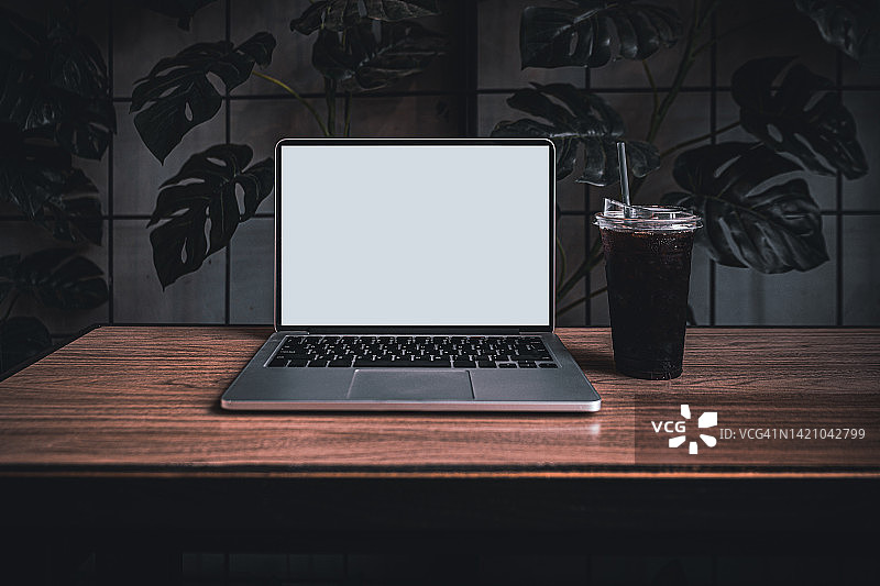 咖啡馆背景中桌子上的笔记本电脑空白屏幕图片素材