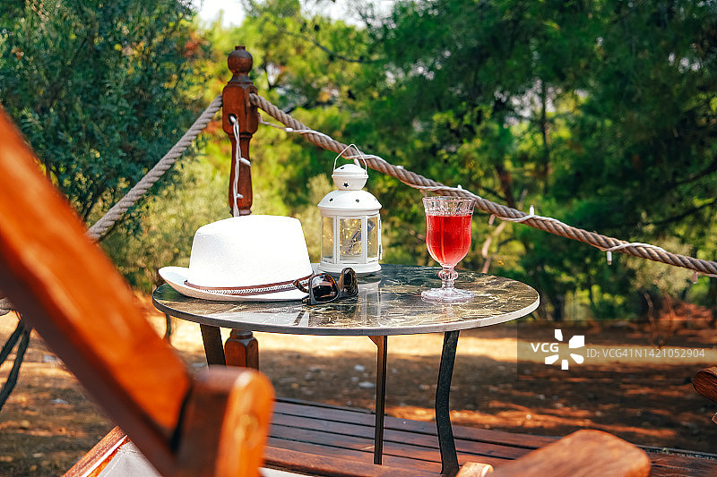 森林露营餐桌上的葡萄酒、太阳镜和帽子图片素材