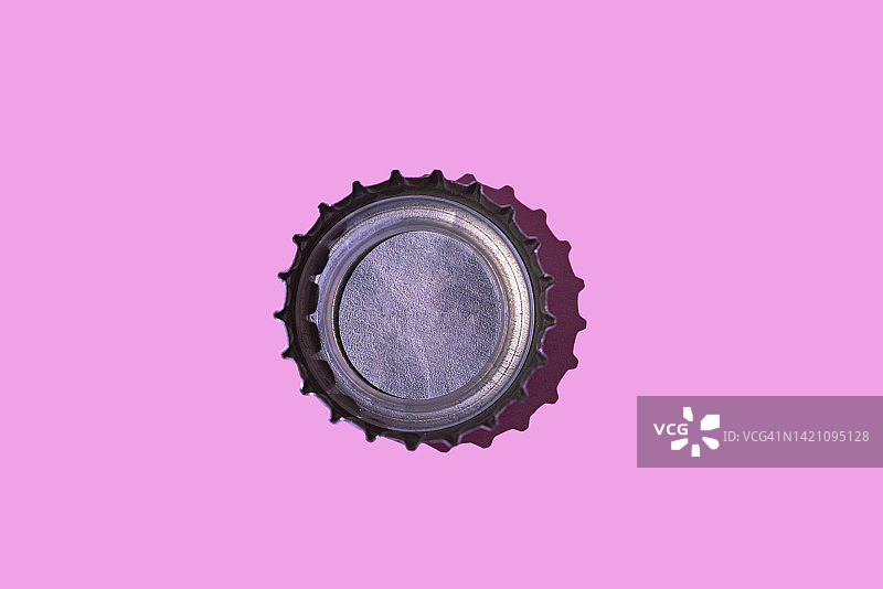 粉色背景上的瓶子顶部：饮料、酒精和金属制品概念图片素材