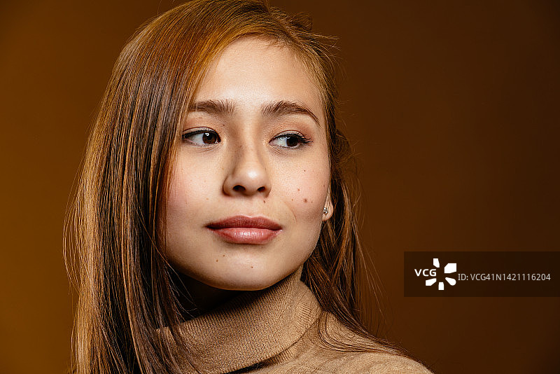 看向一侧的影棚长发亚洲年轻女性图片素材