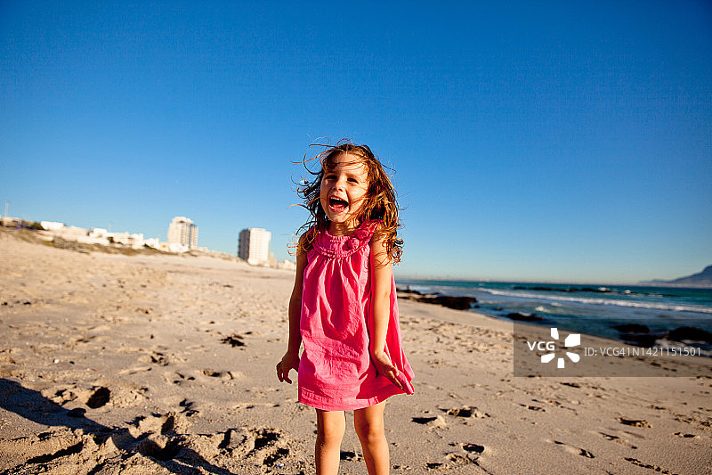 兴奋的小女孩在海滩上享受美好的一天图片素材