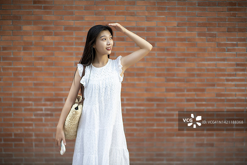 年轻女子站在墙前图片素材