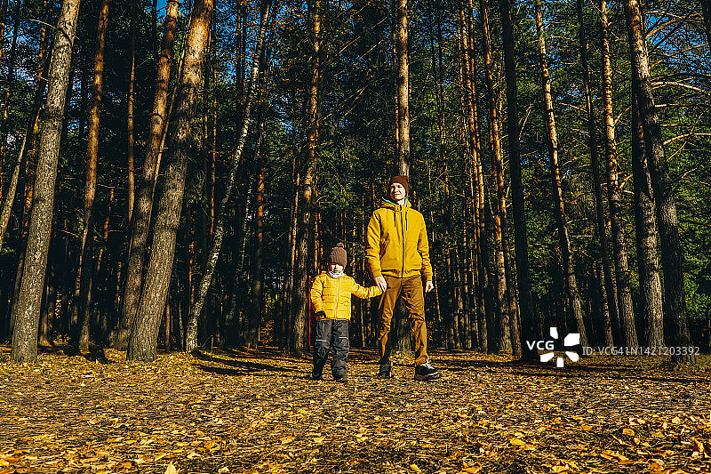 父子在秋日森林中玩耍图片素材
