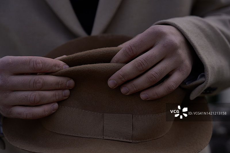 戴着米色时尚帽子的男士手部特写图片素材