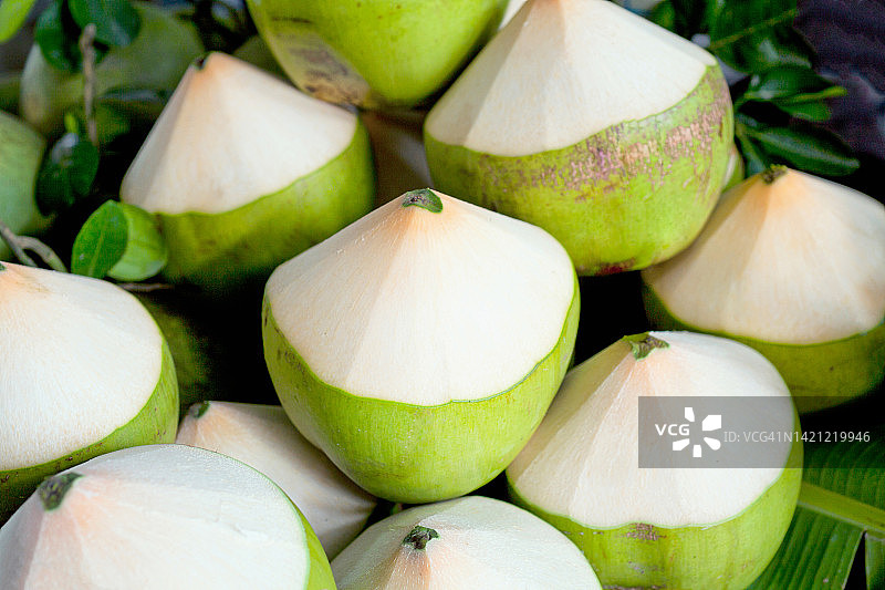 用于饮用的热带嫩椰子自然背景下的堆叠嫩椰子图片素材