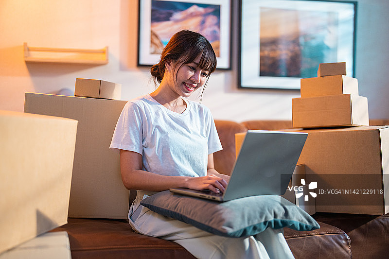 年轻女子在家用笔记本电脑和信用卡支付账单，进行网上购物图片素材