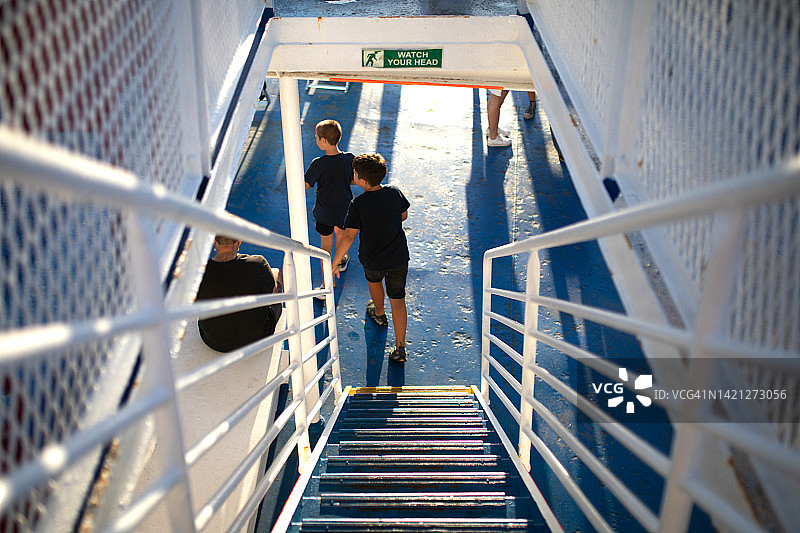 两个男孩在船上跑下楼梯图片素材