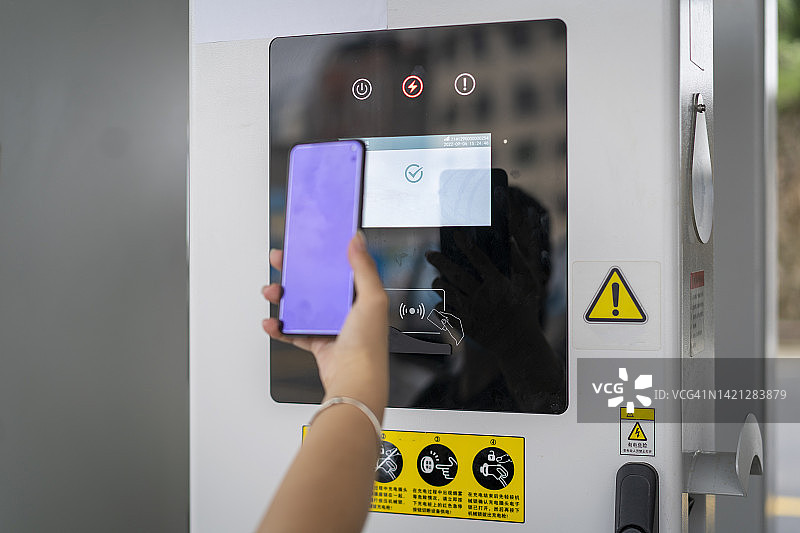 女人用手机扫描充电站图片素材