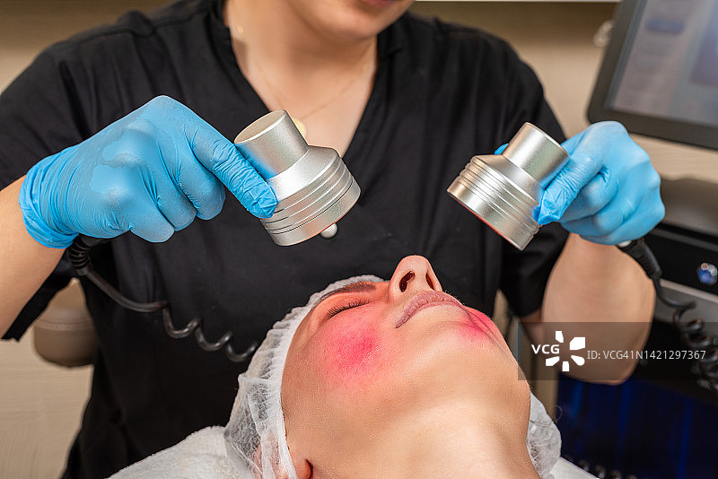 美容师使用红光进行皮肤护理图片素材