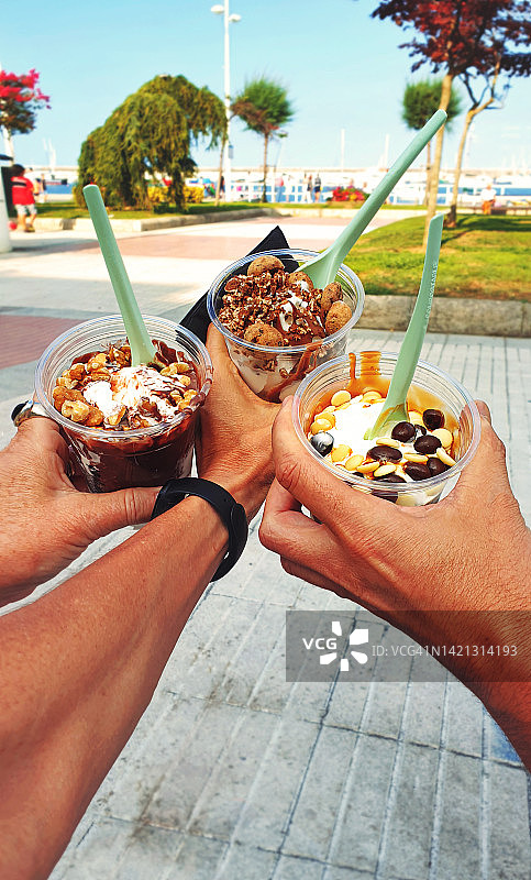 三位朋友或家人手中拿着三个冰淇淋特写图片素材