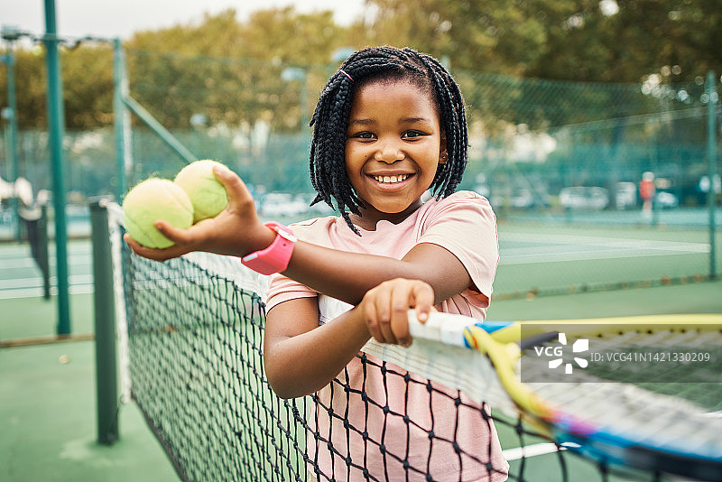 儿童网球运动：女孩在运动场练习，快乐微笑图片素材