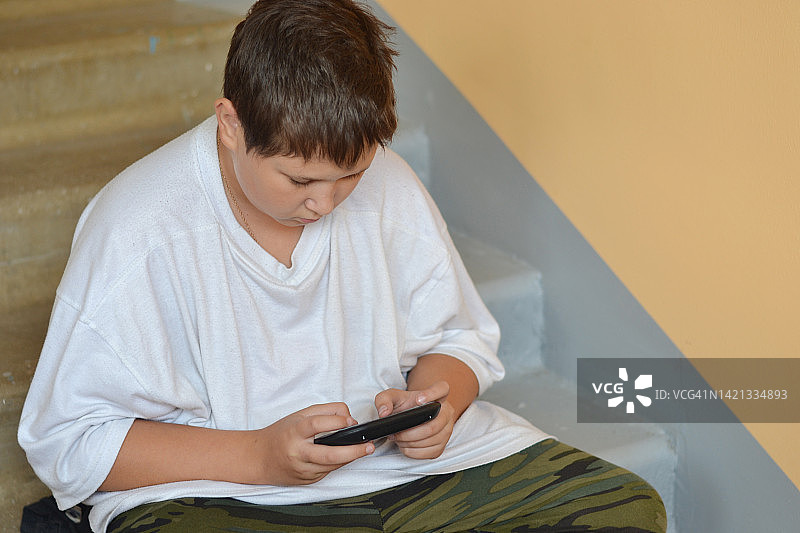 使用智能手机的青少年男孩肖像图片素材