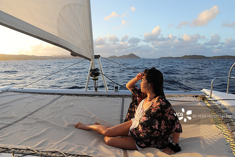 在加勒比海日落帆船上的亚洲女孩图片素材