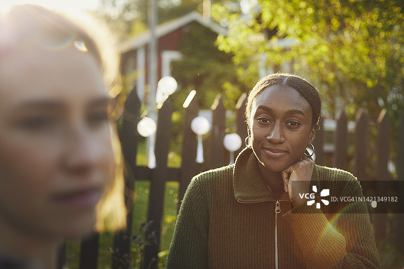 在花园餐桌旁的微笑女人图片素材