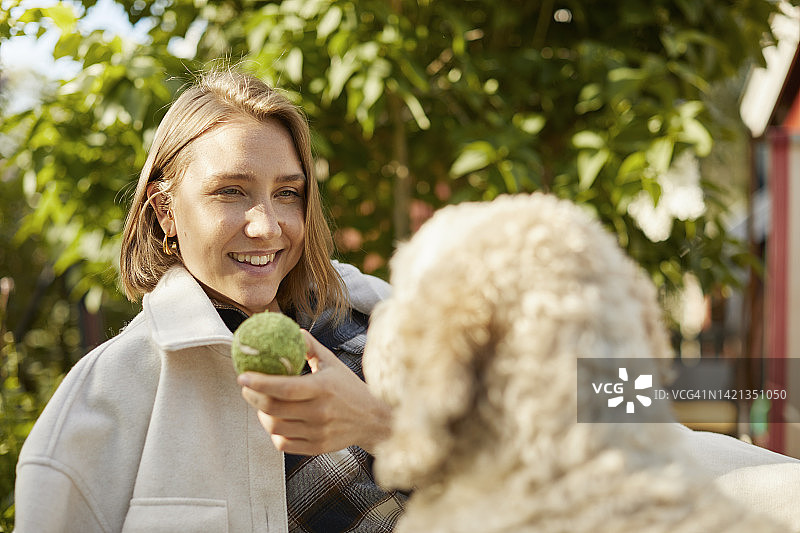 在花园里和狗一起放松的女人图片素材