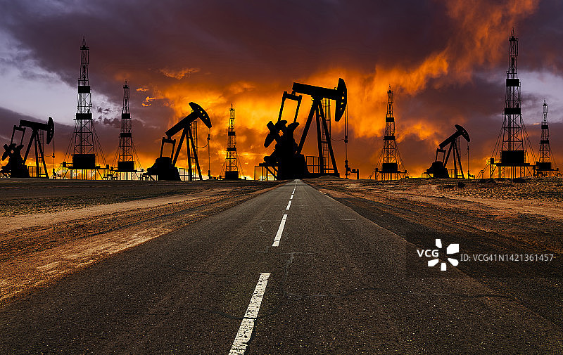 日落时分的油田，钻机和抽油泵，世界石油工业图片素材
