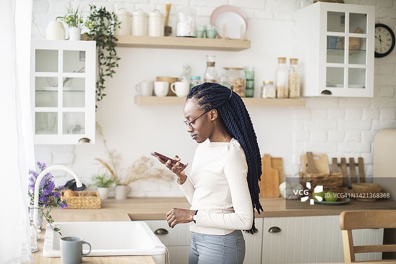 用扬声器模式通过电话交谈的年轻非洲女性图片素材