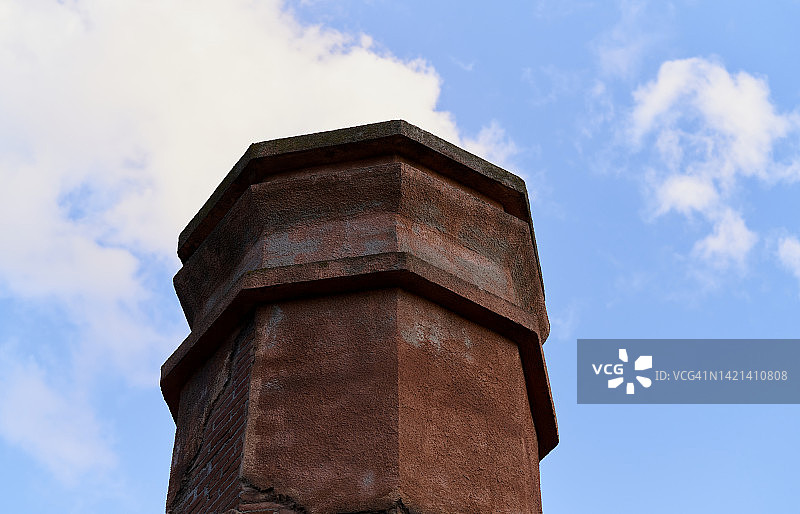 底部有砖块的生锈的工业烟囱，背景是天空图片素材