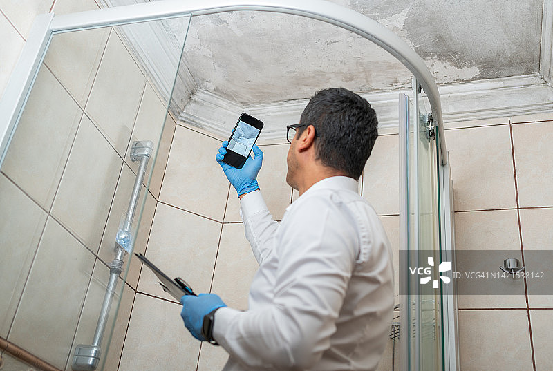 男人检查发霉的白墙图片素材