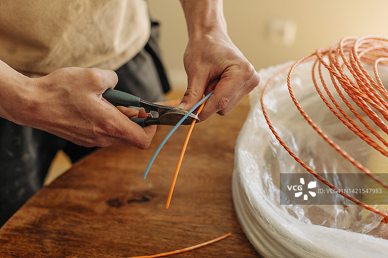 男电工用钳子剪电缆图片素材