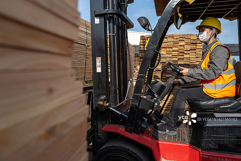 女司机在木材厂打开叉车图片素材
