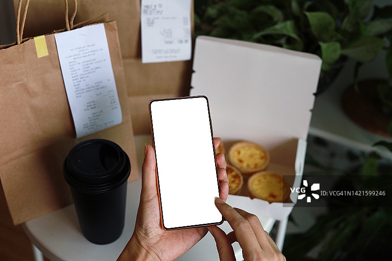 女人手持空白屏幕智能手机并接收外卖订单的特写图片素材