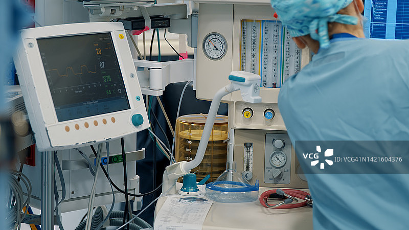 麻醉师查看监护仪，观察病人的身体指标和生命支持图片素材