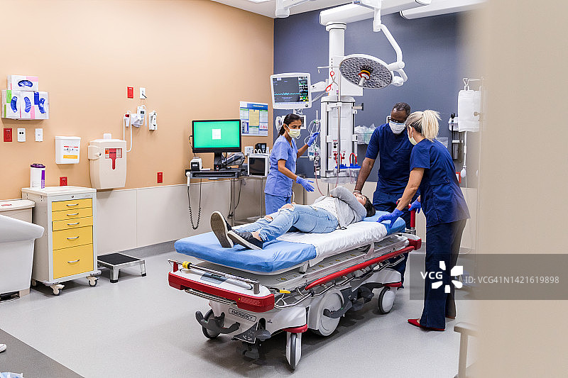 急诊室医护人员帮助痛苦的年轻女子图片素材