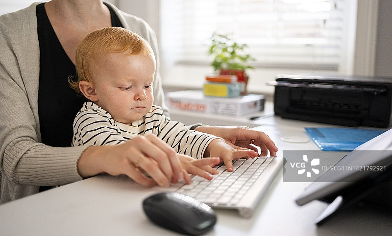 母亲在家教可爱的男孩使用电脑特写图片素材
