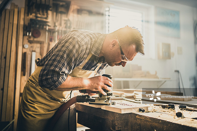 中年男人在车间里砍木头图片素材