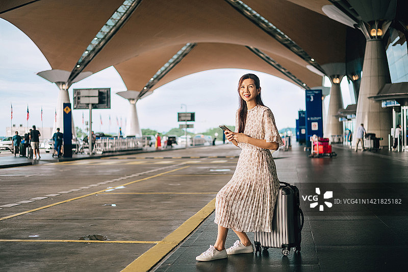 在机场携带行李等待出租车的女人图片素材