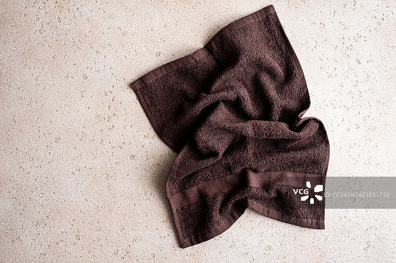 混凝土背景上的棕色浴巾特写，俯视角度图片素材