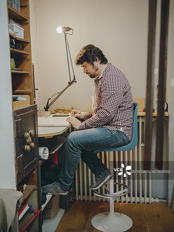 在古董店的办公桌上看书的成熟男企业家图片素材