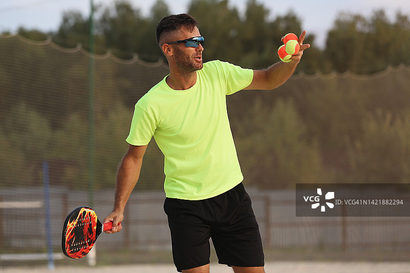打沙滩网球的年轻业余男运动员图片素材