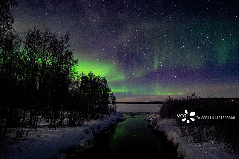 小河上空的绿色北极光图片素材