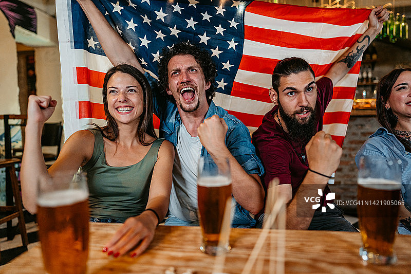 朋友们在酒吧观看体育比赛，为美国队加油图片素材