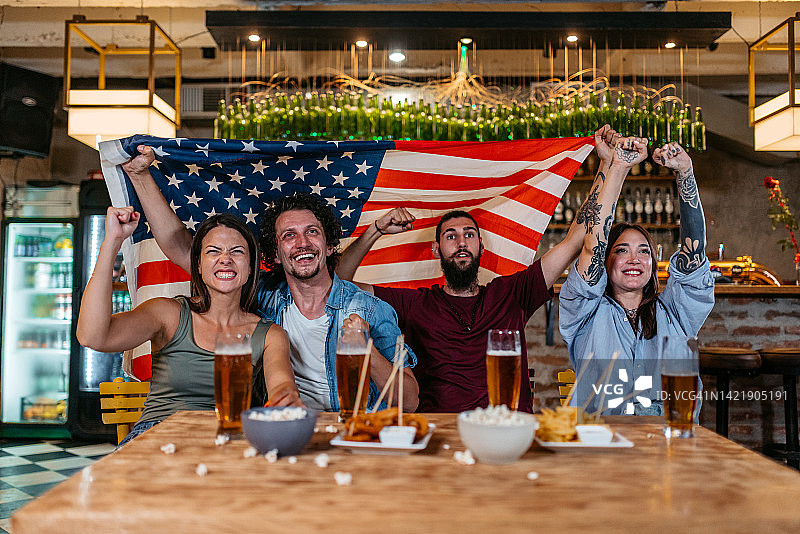 朋友们在酒吧观看体育比赛，为美国队加油图片素材
