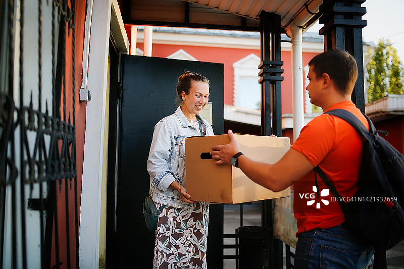 中年妇女在门廊迎接快递员图片素材