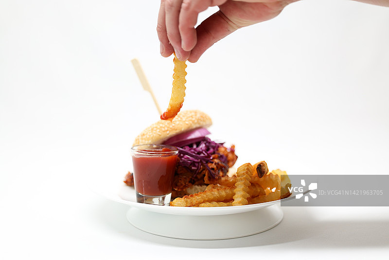 成年人将沾有番茄酱的咸炸薯条拿出图片素材