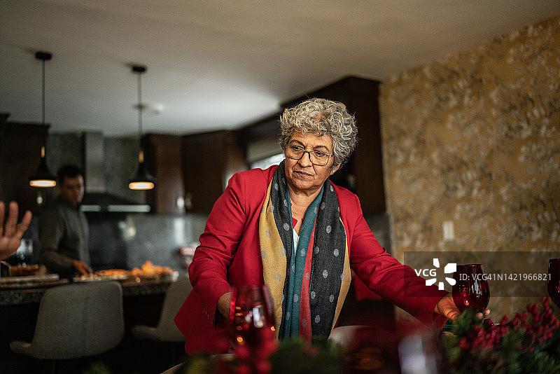 年长的女人在家准备圣诞餐桌图片素材