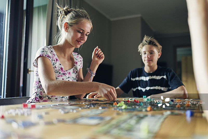 青少年在家一起玩大型现代桌游图片素材