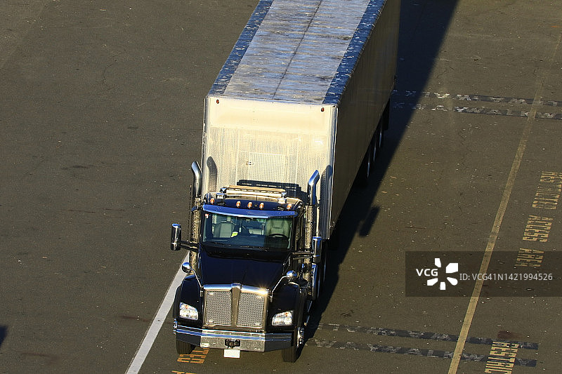 停在仓库的带货运拖车的半挂卡车图片素材