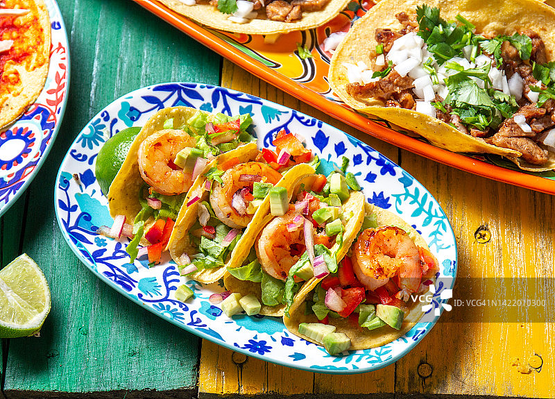 彩色木质背景上的墨西哥虾肉卷饼图片素材