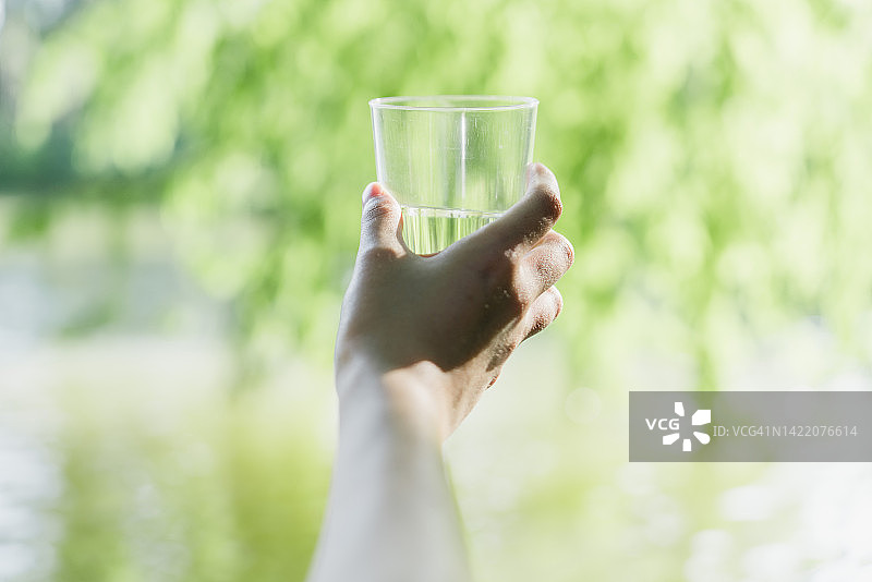 手在森林中拿着一个水杯图片素材