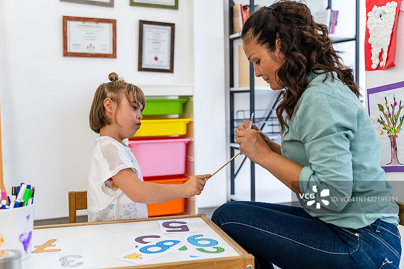 残疾学生和她的老师在做数学题图片素材